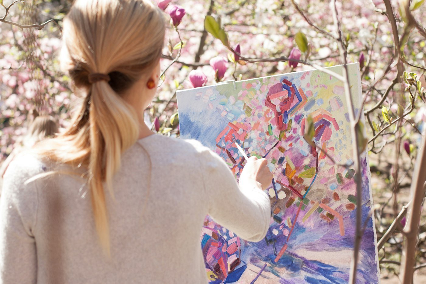 Student painting a colourful canvas outdoors