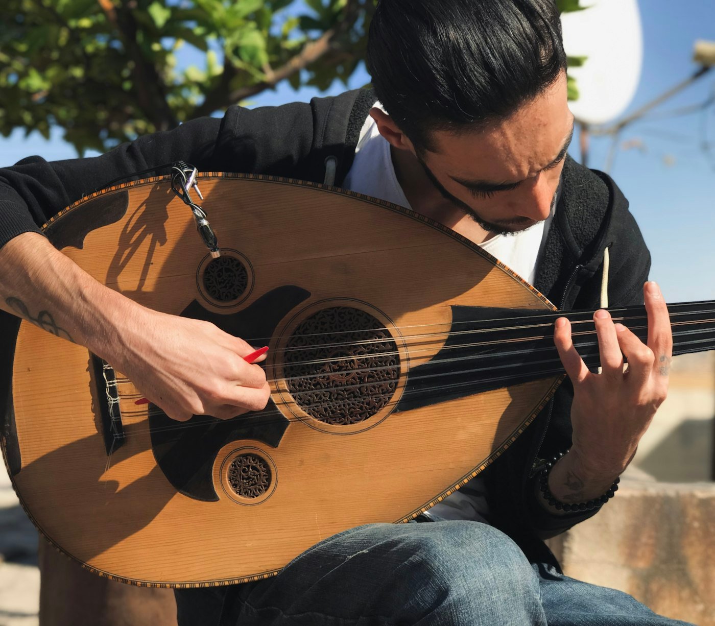 Musician playing the oud with a risha