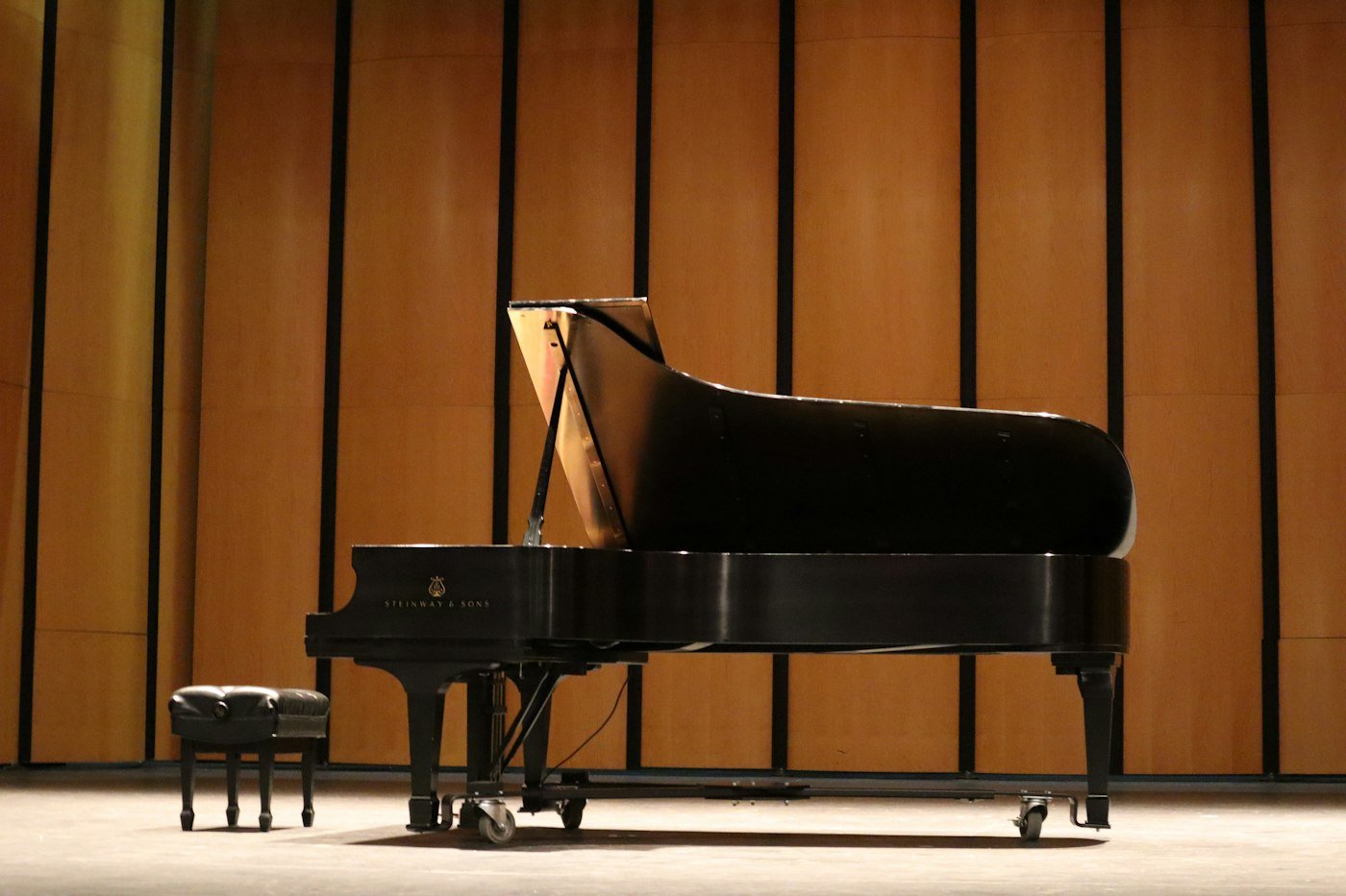 Black grand piano on a wooden concert stage